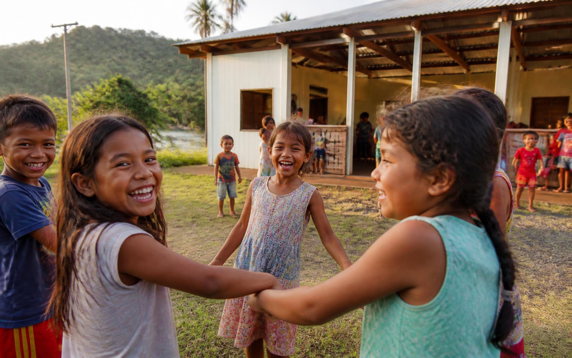 Children laughing together outside the Hearts 4Kids community center in El Triunfo, Ecuador